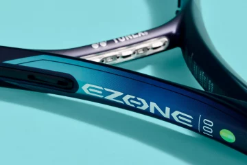 An image of the yonex ezone racket zoomed in on the throat pictured against a light blue background intended to show off the racket for a comparison of all the different types of Yonex EZONE rackets